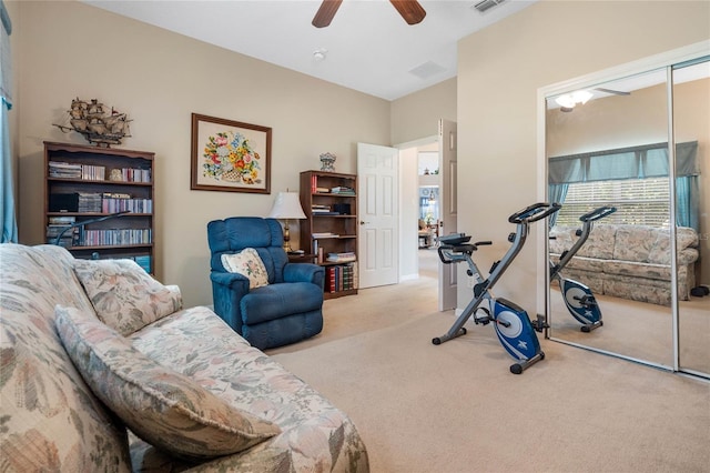 exercise room with ceiling fan and light carpet