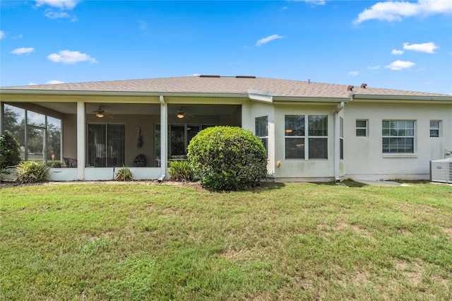 rear view of property with central AC, ceiling fan, and a yard