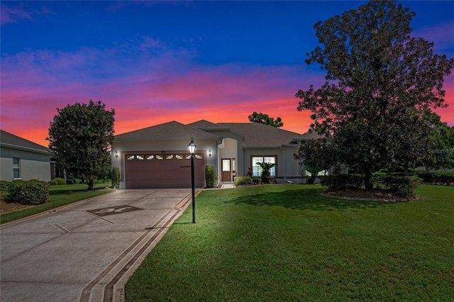 view of front of home with a yard and a garage