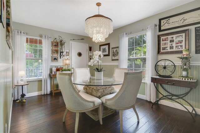 dining room with plenty of natural light, dark wood-type flooring, and an inviting chandelier