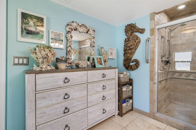 bathroom featuring tile patterned flooring, vanity, a textured ceiling, and walk in shower