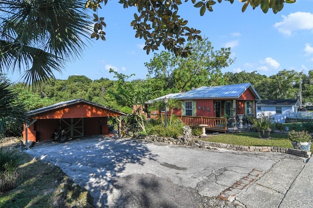 view of front of property featuring a wooden deck and an outbuilding