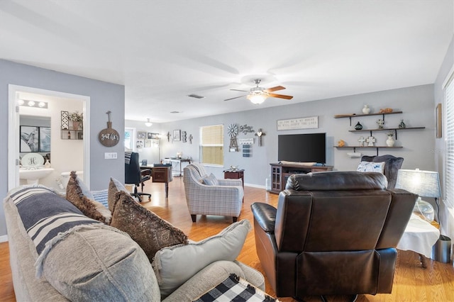 living room featuring ceiling fan and light hardwood / wood-style flooring