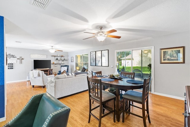 dining room featuring a textured ceiling, light wood-type flooring, and ceiling fan