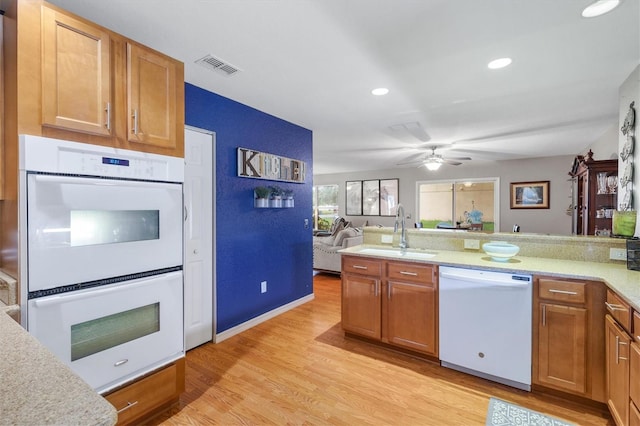 kitchen featuring sink, kitchen peninsula, ceiling fan, white appliances, and light hardwood / wood-style flooring