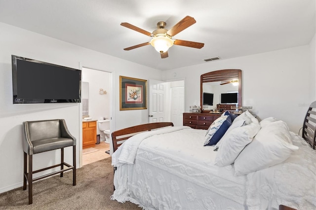 bedroom featuring ensuite bathroom, light carpet, and ceiling fan