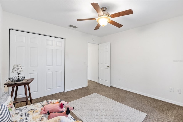 carpeted bedroom featuring ceiling fan and a closet