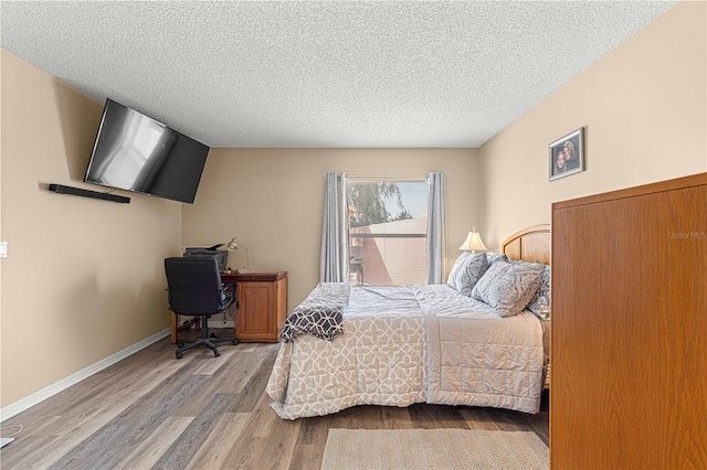 bedroom with hardwood / wood-style flooring and a textured ceiling