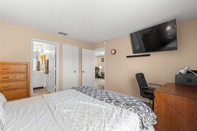 bedroom featuring a textured ceiling and connected bathroom