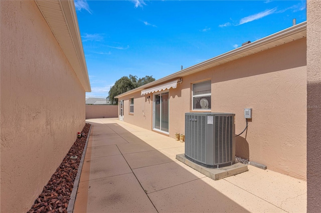 view of side of property with cooling unit and a patio area