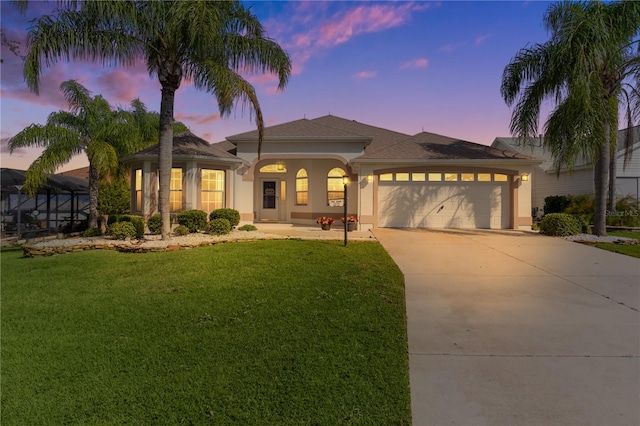 mediterranean / spanish-style home with a lawn and a garage