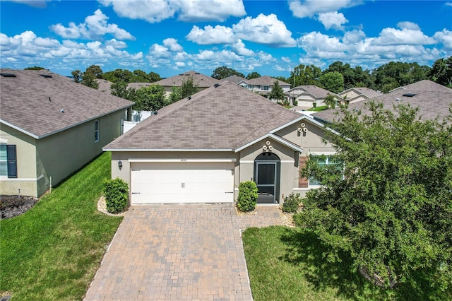 ranch-style house featuring a front lawn and a garage