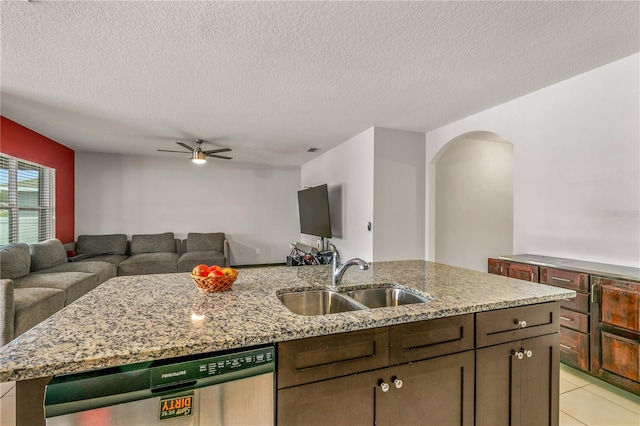 kitchen with light stone countertops, a textured ceiling, ceiling fan, stainless steel dishwasher, and sink