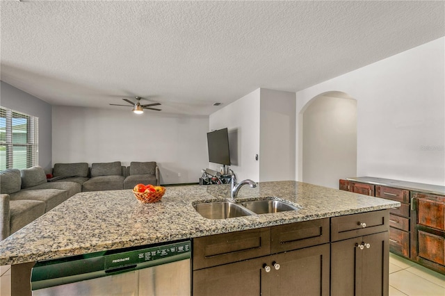 kitchen featuring a textured ceiling, stainless steel dishwasher, sink, and ceiling fan