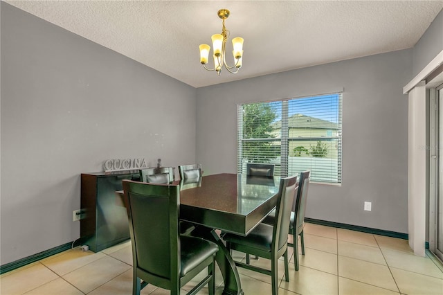 tiled dining room featuring a textured ceiling and a chandelier