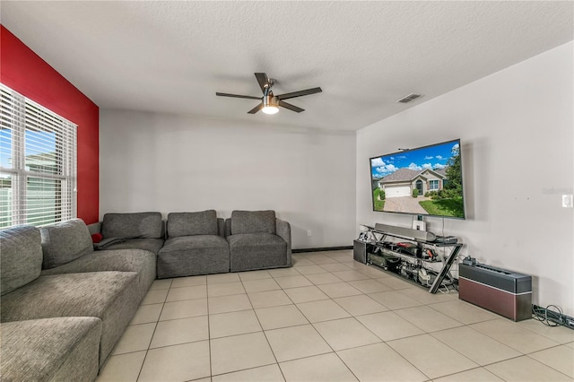 tiled living room featuring a textured ceiling and ceiling fan