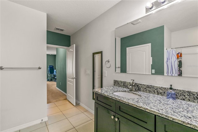 bathroom featuring vanity, a textured ceiling, and tile patterned floors