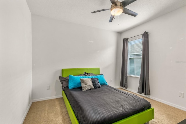 carpeted bedroom featuring ceiling fan and a textured ceiling