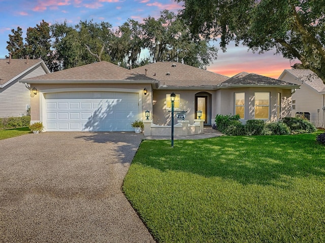 ranch-style house with a yard and a garage