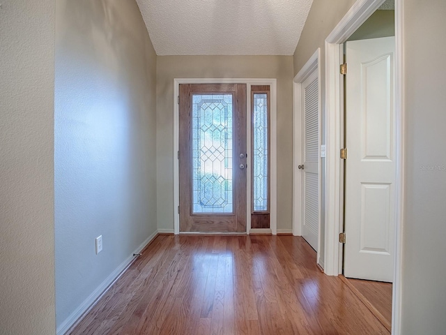 foyer with light hardwood / wood-style flooring and a textured ceiling