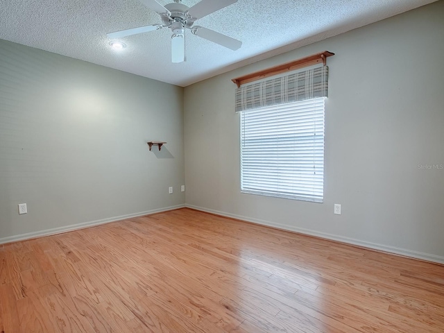 spare room with light hardwood / wood-style floors, ceiling fan, and a textured ceiling