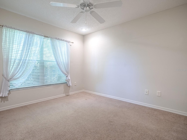 carpeted spare room with a textured ceiling and ceiling fan