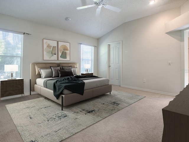 bedroom with lofted ceiling, ceiling fan, carpet floors, and a textured ceiling