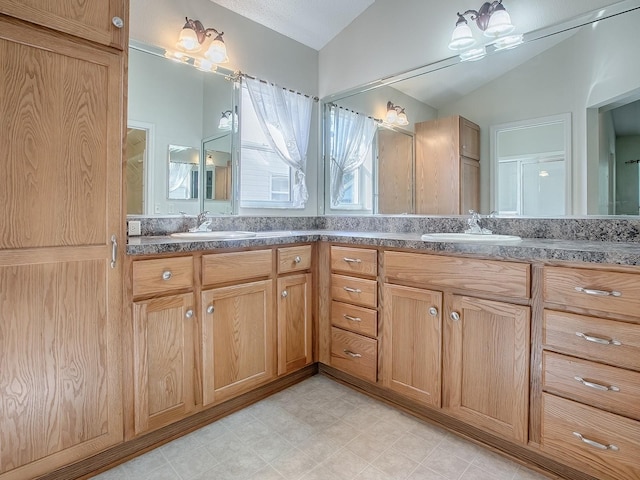 bathroom with a textured ceiling, lofted ceiling, and vanity