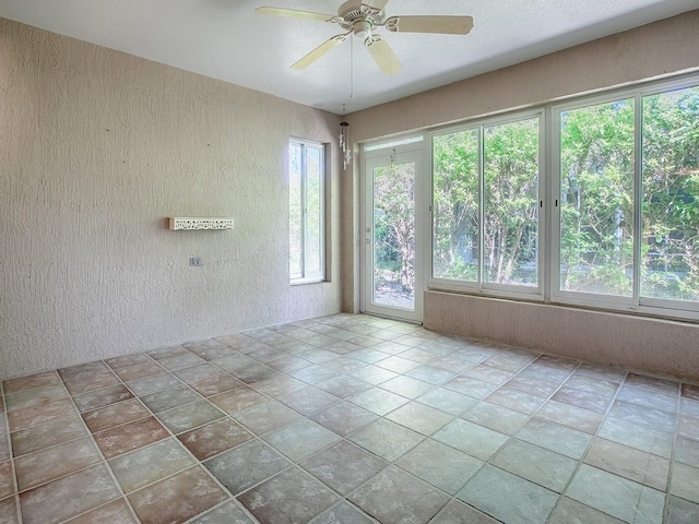 empty room with a wealth of natural light and ceiling fan