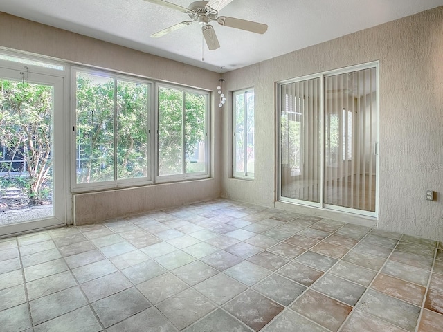 spare room with a textured ceiling, ceiling fan, and a wealth of natural light