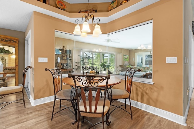 dining room featuring ceiling fan with notable chandelier and light wood-type flooring