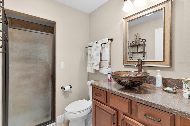 bathroom featuring a shower with door, vanity, and toilet