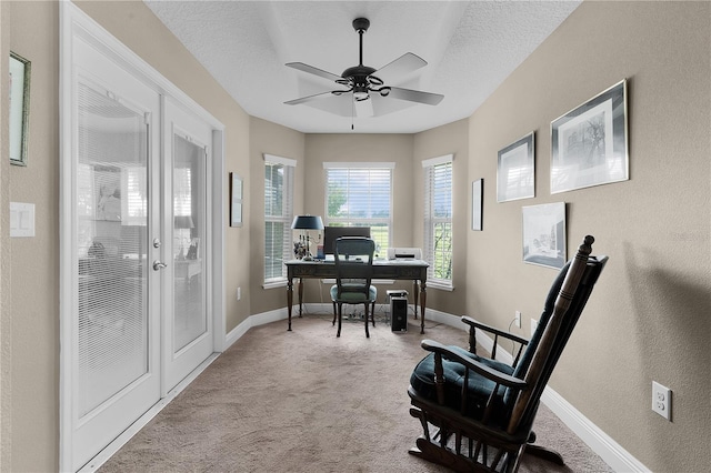 carpeted office featuring ceiling fan and a textured ceiling