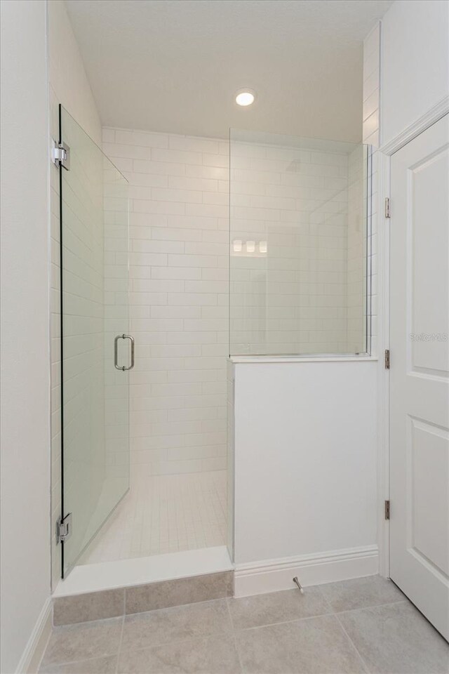 bathroom featuring tile patterned flooring and an enclosed shower