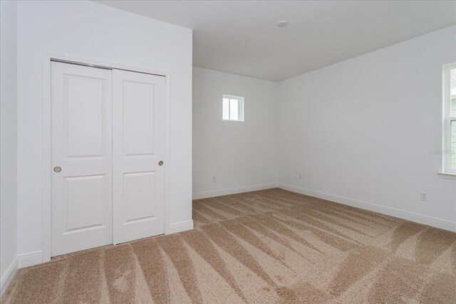 unfurnished bedroom featuring carpet floors and a closet