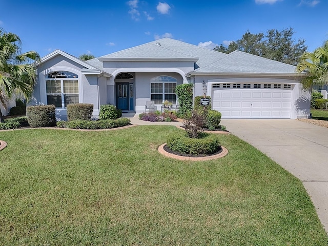 ranch-style home with a garage and a front lawn