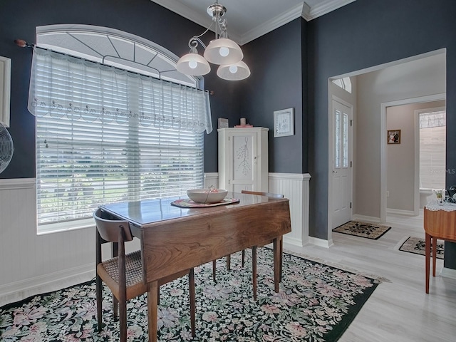 dining area with light hardwood / wood-style floors, a notable chandelier, and ornamental molding