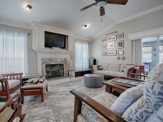 living room with ceiling fan, ornamental molding, vaulted ceiling, and a fireplace