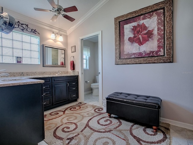 bathroom with lofted ceiling, toilet, crown molding, vanity, and ceiling fan