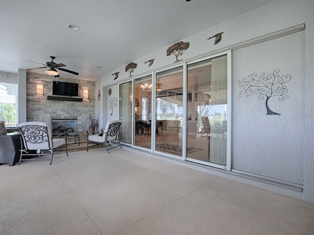 view of patio / terrace with ceiling fan and a stone fireplace