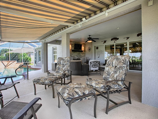 view of patio featuring an outdoor living space, ceiling fan, and glass enclosure