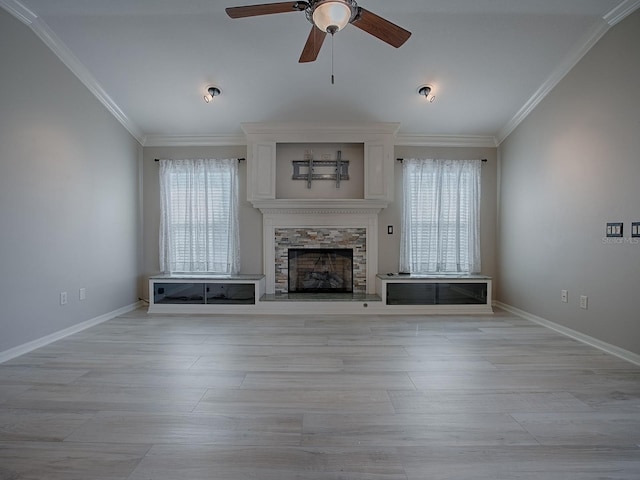 unfurnished living room featuring a stone fireplace, ornamental molding, and ceiling fan