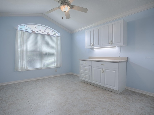 interior space with lofted ceiling, ornamental molding, and ceiling fan