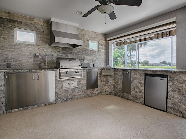 kitchen with wall chimney exhaust hood, stainless steel fridge, and ceiling fan