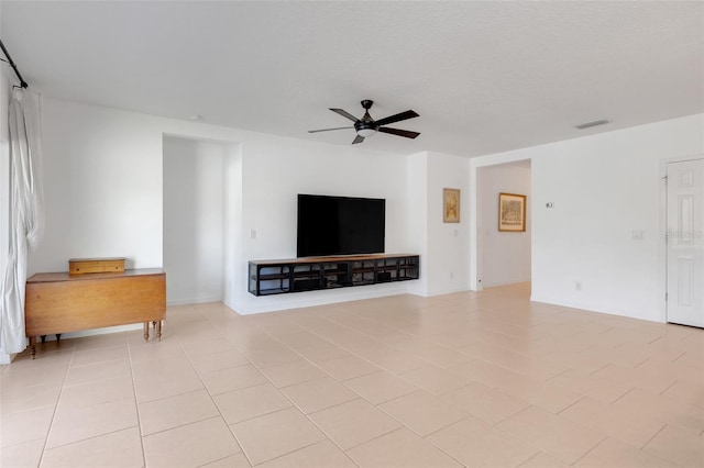 unfurnished living room featuring ceiling fan, light tile patterned flooring, and a textured ceiling