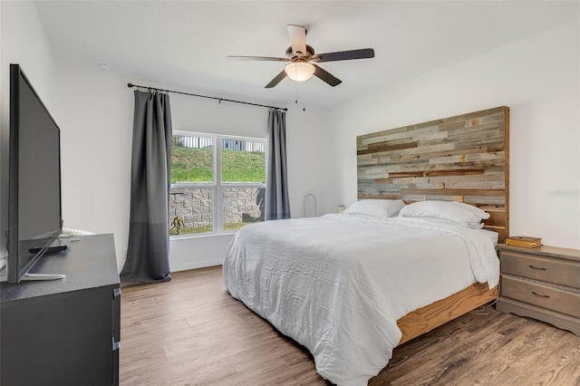 bedroom with ceiling fan and dark wood-type flooring