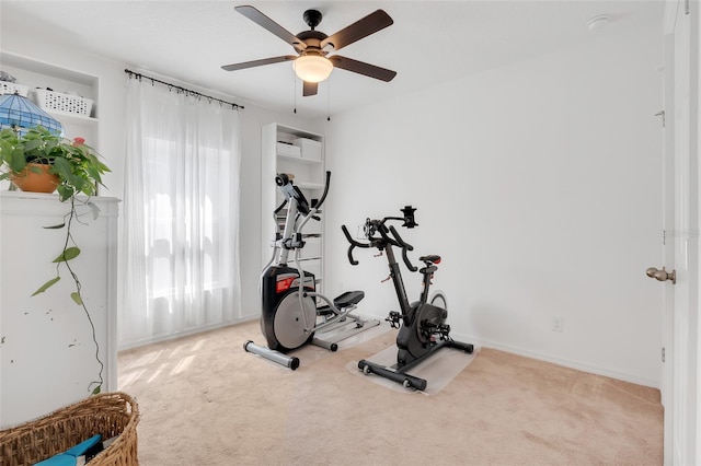 workout area featuring light carpet and ceiling fan