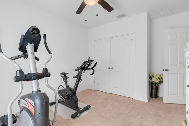 workout area featuring ceiling fan and light colored carpet