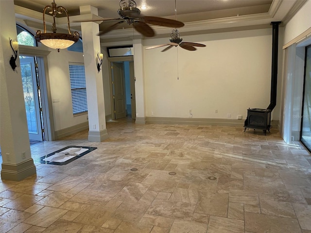 unfurnished room featuring crown molding, ceiling fan, and a wood stove