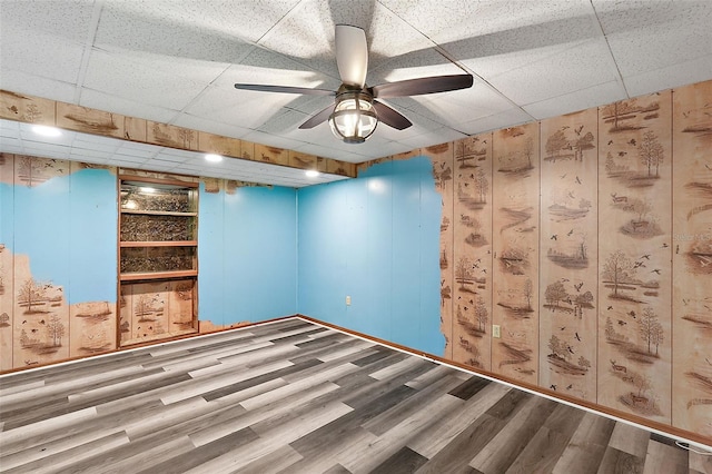 unfurnished room with wood-type flooring, a paneled ceiling, and ceiling fan